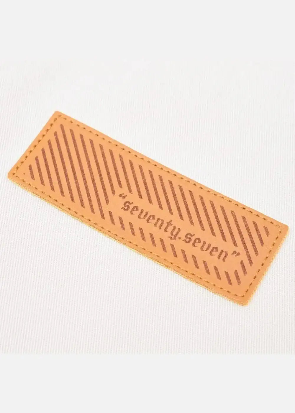 Chi tiết logo da nâu ghi chữ "seventy.seven" trên áo thun nam, thiết kế tinh tế, tôn dáng