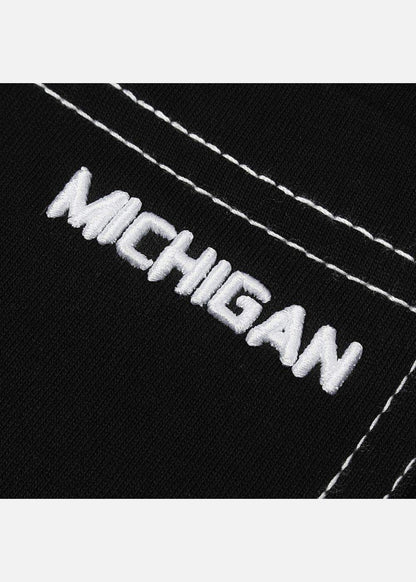 Chi tiết thêu chữ MICHIGAN trắng trên vải đen, đường chỉ nổi bật, thiết kế thời trang nam