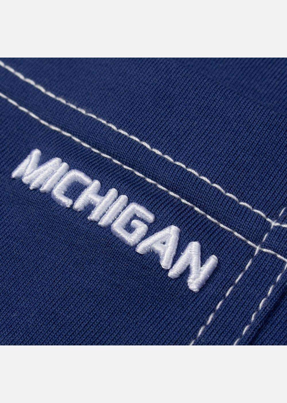 Chi tiết thêu chữ MICHIGAN trên áo thun nam màu xanh đậm, đường may trắng nổi bật