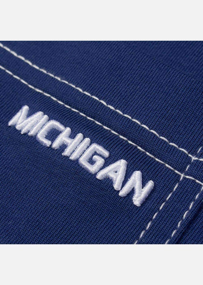 Chi tiết thêu chữ MICHIGAN trên áo thun nam màu xanh đậm, đường may trắng nổi bật