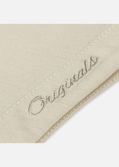Chi tiết thêu chữ 'Originals' trên vải áo nam màu be, chất liệu mềm mịn, thiết kế tinh tế
